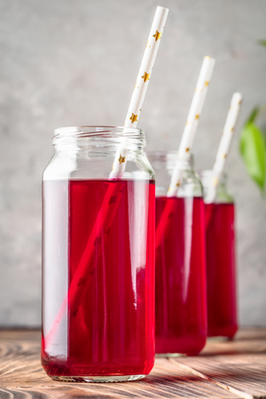 Beverage compote of red berries black currant cherries blueberries in cocktail jars with straws drinking. Concept food homemade preserving organic ingredients for a recipe.の写真素材