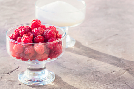 Glass of fresh raspberries and white sugar gardening gastronomy harvestの写真素材