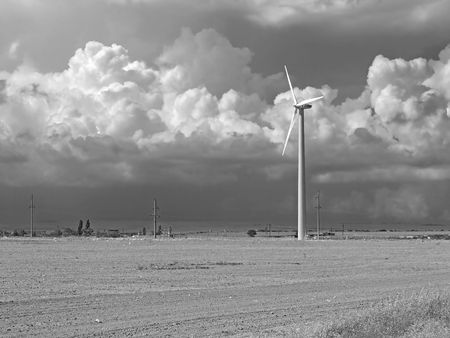 Wind power station. Single wind-turbine on the  field with cloudy sky. Crimea, Ukraine         の写真素材