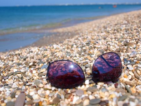 Sunglasses lying on a summer stony beach. Evpatoria, Crimea, Ukraine      の写真素材