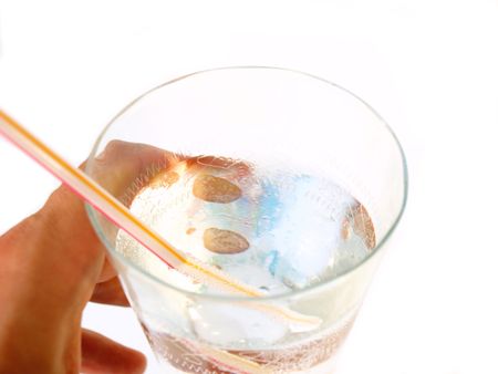 Hand taking a glass of cold mineral water with stick isolated on white backgroundの写真素材