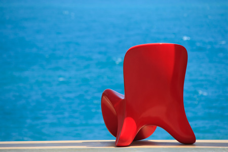 Red chair on blue sea backgroundの写真素材