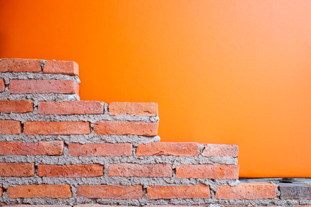 Brick wall and orange leatherette background.の写真素材