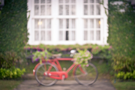 Red vintage bicycle with a flowers in a basket, Blur image for background.の写真素材