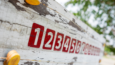 Red numbers on old wood wall background.の写真素材