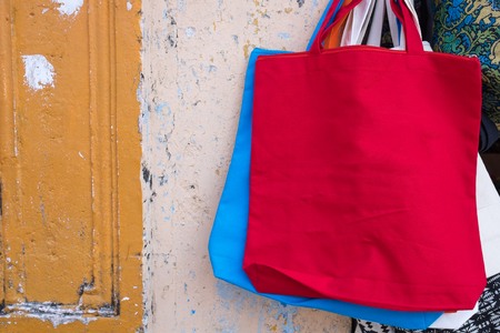 Colorful fabric bags against old wall background.の写真素材