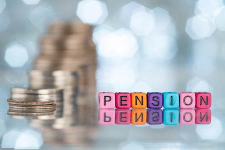 PENSION word on alphabet block with stacked coins. Conceptual image.の写真素材