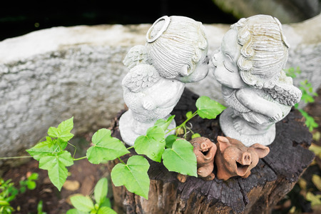 Two little kids statue kissing in the garden.の写真素材