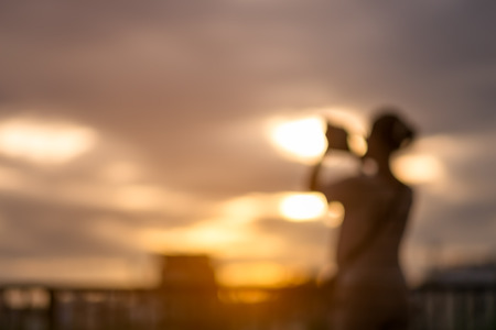 Blur woman using smart phone take picture on sunset.の写真素材