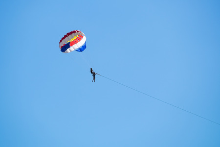 Parasailing against a blue sky.の写真素材