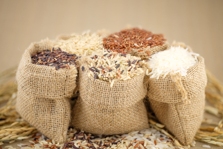 Jasmine rice, Brown rice, Red rice, Mixed rice and Riceberry rice in small hemp sacks.の写真素材