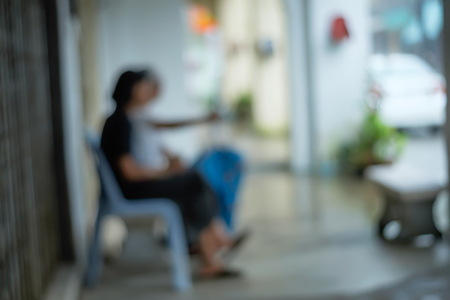 Blurred image of old woman sit on the street.の写真素材