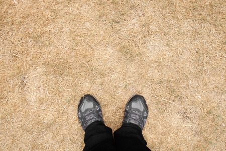 Top view of shoes on ground with dried grass background.の写真素材