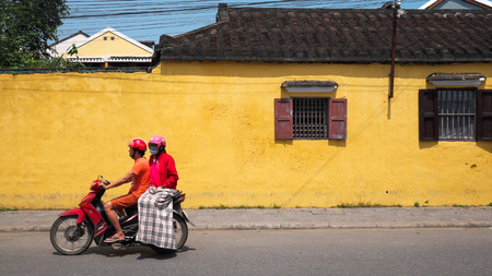 HOI AN, VIETNAM - MARCH 02, 2017:  Local residents on motorcycle riding through the streets of Hoi An, Vietnam.のeditorial素材