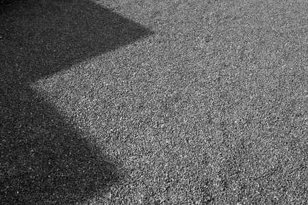 Shadow on Granite gravel of macadam, Rock blue gray crushed for construction on the ground, Scree texture background.の写真素材