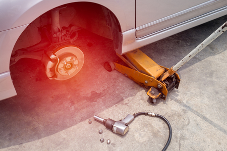 Car jack to lift car, changing car tire.の写真素材