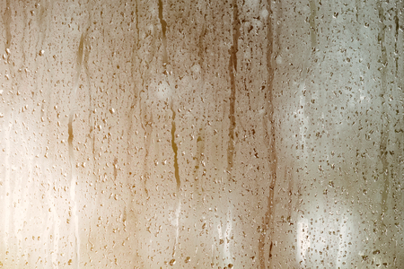 Rain drops on window with sun light.の写真素材