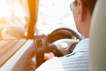Man driving car from rear view on the road.