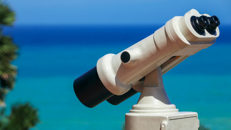 White coin operated binoculars camera setup at Phromthep cape viewpoint in Phuket, Thailand.