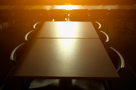 Empty table and chairs in canteen with sun light.の写真素材