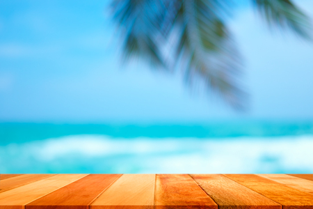 Wood plank with blurred sea and coconut tree background. Concept of beach in summer.の写真素材