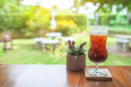 Iced tea on wooden table against garden background.の写真素材