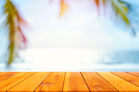 Wood plank with blurred sea and coconut tree background. Concept of beach in summer.の写真素材