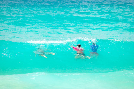 Group of tourists dive underwater under breaking wave.の写真素材