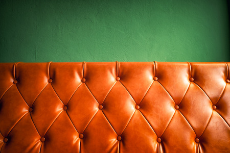 Orange leather sofa and green wall background.