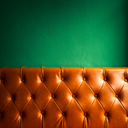 Orange leather sofa and green wall background.の写真素材