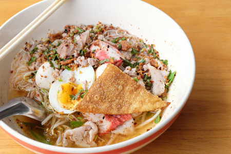 Spicy pork Tom yam noodle on table.の写真素材