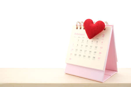 February Calendar 2021 page and red heart on wooden desk isolated white background, Valentine's Day Concept.の写真素材