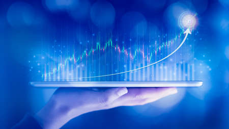 Woman hand showing virtual hologram stock from tablet, Business growth concept,Stock market graph or forex trading chart,Planning and strategy,Progress or success,Digital asset,Trader or investor.の写真素材