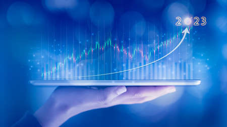 Woman hand showing virtual hologram stock from tablet,2023 business growth concept,Stock market graph or forex trading chart,Planning and strategy,Progress or success,Digital asset,Trader or investor.の写真素材