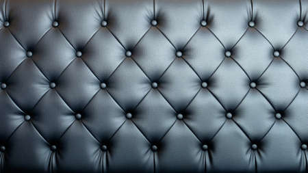 Black artificial leather sofa with rivets texture for background.