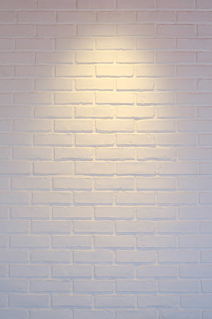 Warm light spot with white brick wall backgrounds.の写真素材