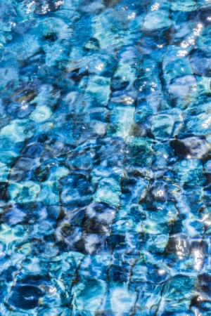 Moving water in blue tiled fountain poolの写真素材