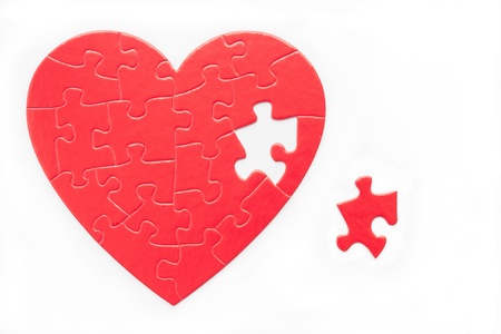 Red heart puzzle and piece isolated on whiteの写真素材