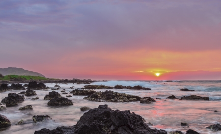 Intensely colorful sunrise over the ocean at Sandy Beach in Oahu, Hawaiiの写真素材