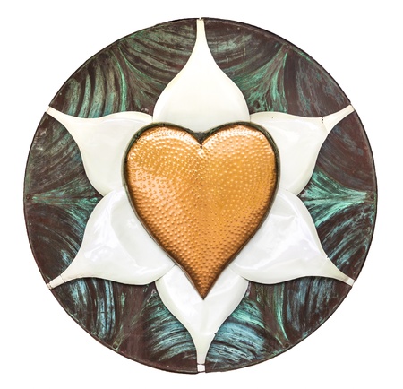 A dimpled copper heart on a white metal flower inside of a brushed disk with patinaの写真素材