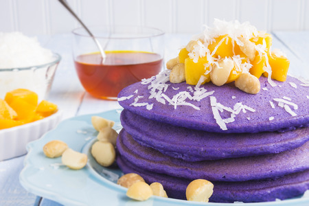Taro pancakes topped with mango, macadamia nuts, shredded coconut and lilikoi syrupの写真素材