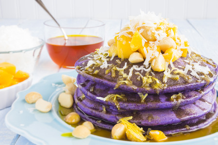 Taro pancakes topped with mango, macadamia nuts, shredded coconut and lilikoi syrupの写真素材