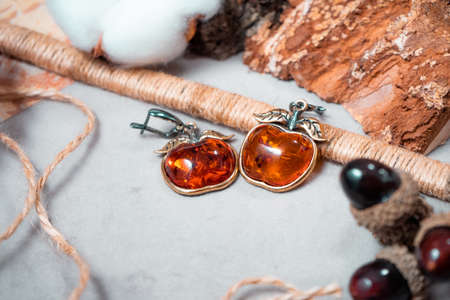 Earrings in the form of apples made of bronze and amber close-upの写真素材