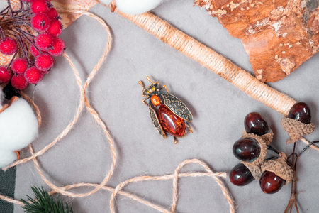 Suspension in the form of a beetle of bronze and amber on a gray backgroundの写真素材