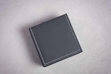 Velvet black gift case stitched with white threads on a gray backgroundの写真素材
