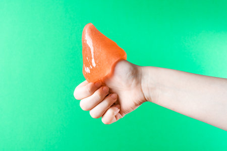 Honey flows down the arm, which shows the thumb up, like, close-up on a green backgroundの写真素材