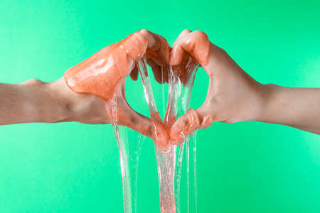 Liquid wax flows down the arms, showing the heart on a green backgroundの写真素材