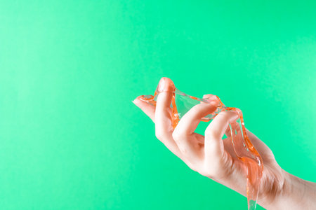 Slime spreads on the fingers against the background of green ChromaKeyの写真素材