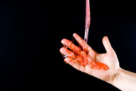 Slime spreads on the fingers against the background of black ChromaKeyの写真素材