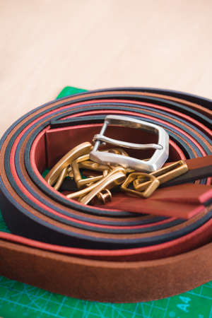 Leather straps lying on a green stand on the tableの写真素材